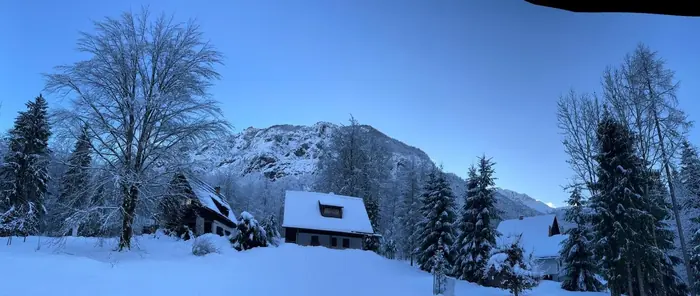 Koča pri Rdeči Bukvi in okoliške koče pod snegom pozimi